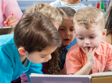 3 year old children looking at a book